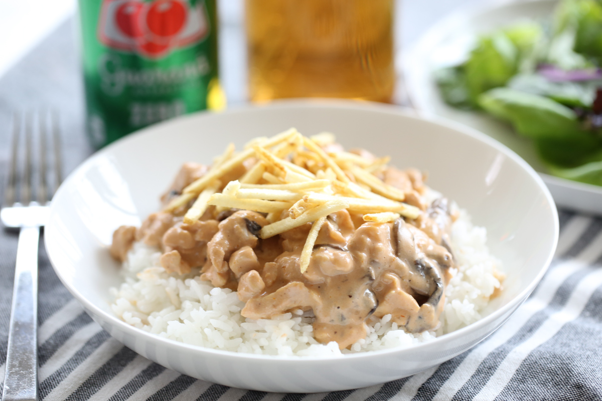brazilian stroganoff over rice on a white plate