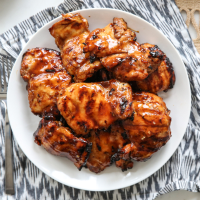 Huli Huli grilled chicken thighs on a white plate.