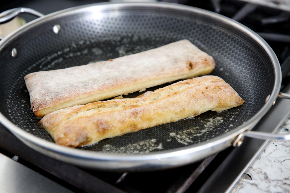 toasting a roll in a pan